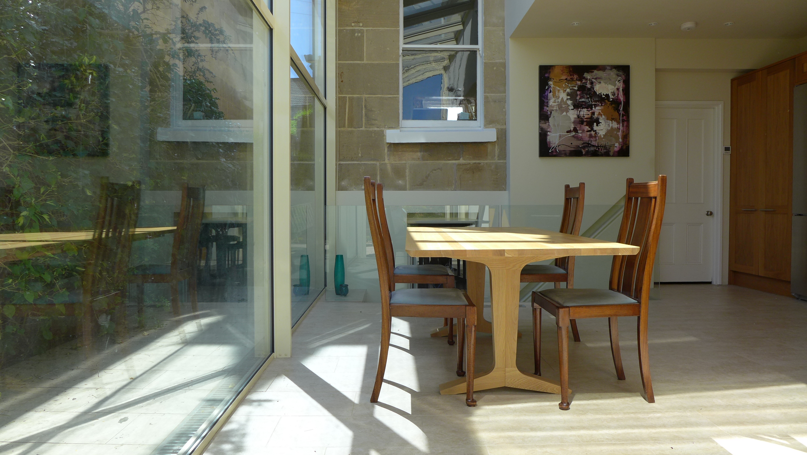 dining area in glass extension bathed in sun